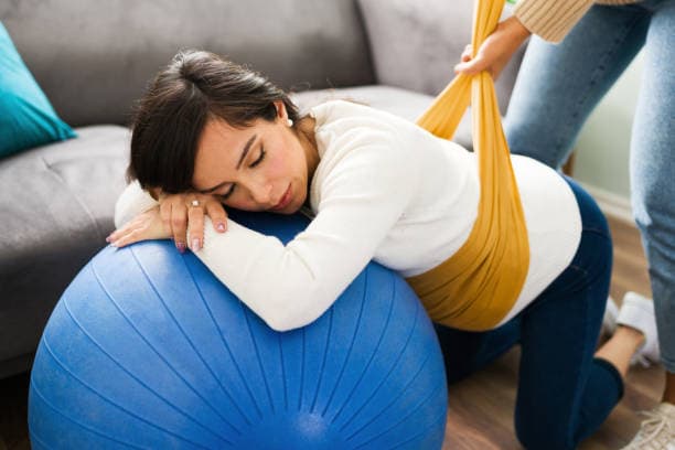 Best pregnancy stretches for back pain relief featuring a pregnant woman stretching