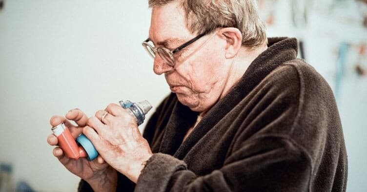 Elderly person using inhaler for COPD management