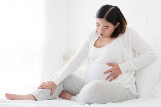 Woman experiencing cramping in early pregnancy