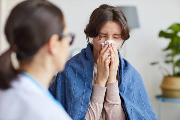 Doctor consulting a patient with flu symptoms