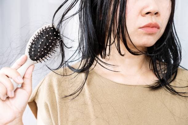 Woman experiencing hair loss due to thyroid symptoms