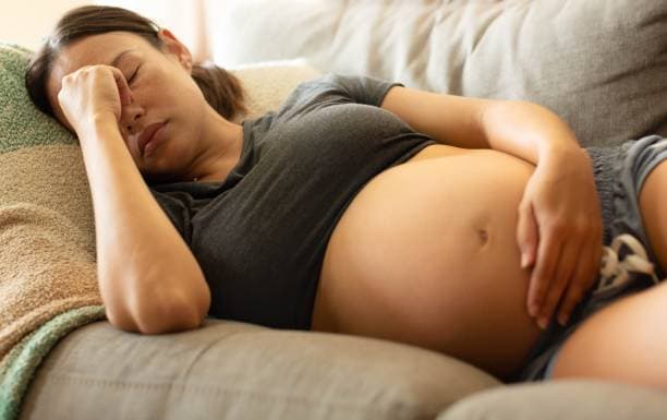Woman experiencing headaches during pregnancy