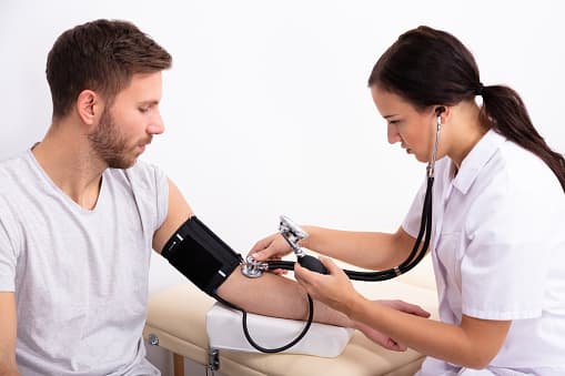 Hero image of a doctor checking blood pressure