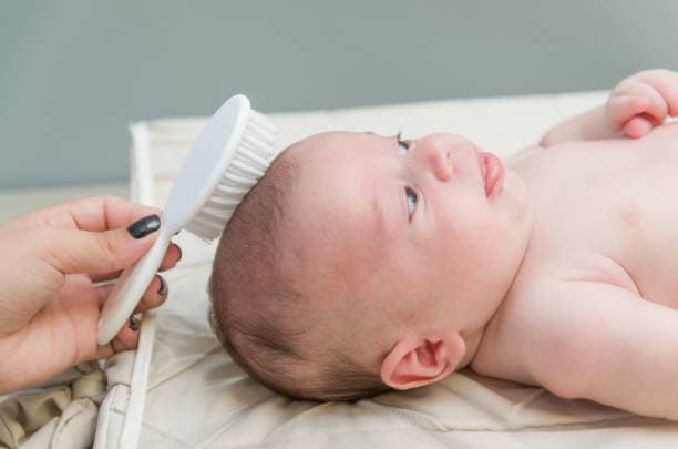 Woman using postpartum hair shedding remedies for healthy hair recovery
