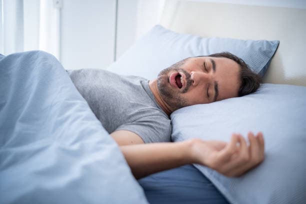 Adult man experiencing sleep apnea symptoms