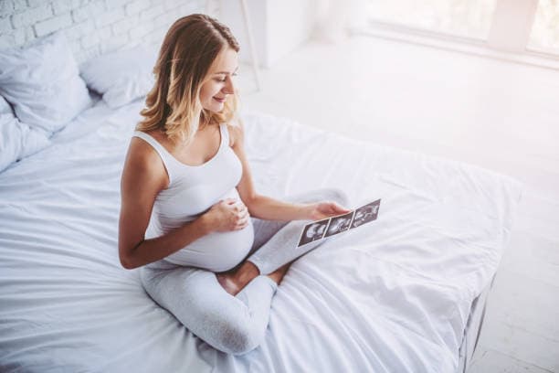 First trimester insomnia tips: A pregnant woman practicing relaxation techniques in bed